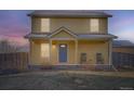 Charming two-story home with a welcoming front porch at dusk at 55410 E 27Th Pl, Strasburg, CO 80136