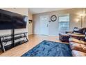 Comfortable living room with wood floors, large TV, and ample seating at 55410 E 27Th Pl, Strasburg, CO 80136