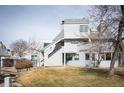 Exterior view of a multi-story townhouse with gray siding and a well-maintained lawn at 17093 E Tennessee Dr # 211, Aurora, CO 80017