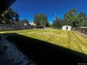 Expansive backyard featuring a lush lawn, privacy fence and storage shed at 235 S Stuart St, Denver, CO 80219