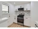 This renovated kitchen offers stainless steel appliances, white cabinets, and modern backsplash at 235 S Stuart St, Denver, CO 80219
