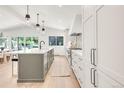 Spacious kitchen with bright white cabinetry, large island and access to dining area at 4930 E Ellsworth Ave, Denver, CO 80246