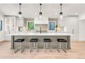 Contemporary kitchen showcasing oversized island with pendant lighting and breakfast bar stools at 4930 E Ellsworth Ave, Denver, CO 80246