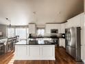 Bright and spacious kitchen with white cabinets, stainless steel appliances, island and adjacent dining area at 6686 Solana Dr, Castle Pines, CO 80108