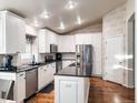 Modern kitchen featuring white cabinets, stainless steel appliances, a kitchen island, and wooden floor at 6686 Solana Dr, Castle Pines, CO 80108