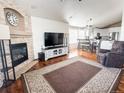 Inviting living room featuring a brick fireplace, modern furnishings, and seamless flow to dining and kitchen at 6686 Solana Dr, Castle Pines, CO 80108