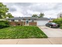 Cozy single-story home features a lush green lawn, brick accents, and an attached garage at 11886 Birch Dr, Thornton, CO 80233