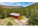 Elevated view of a wood cabin nestled in the mountains, featuring an attached two-car garage at 310 Wendelyn Way, Boulder, CO 80302