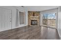 Living room with hardwood floors, stone fireplace, sliding glass doors to balcony, and a large window at 4460 S Pitkin St # 120, Aurora, CO 80015