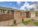 Charming brick home with a well-manicured front porch and a decorative storm door at 11157 W Marlowe Ave, Littleton, CO 80127