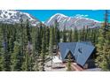 Mountain home with roof, A-frame design, wood paneling and surrounded by lush forest near mountain peaks at 297 Robertson Ln, Breckenridge, CO 80424