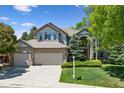 Beautiful two-story home with lush landscaping, a three-car garage, and classic curb appeal at 6393 S Jamaica Ct, Englewood, CO 80111