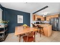 Bright dining area with a wooden table set against a textured blue wall, adjacent to a modern kitchen at 909 N Logan St # 8F, Denver, CO 80203