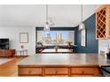 Bright kitchen island with views of the city through a large window, and modern pendant lighting at 909 N Logan St # 8F, Denver, CO 80203