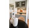 Charming kitchenette with painted cabinets, butcher block countertops, and decorative glassware at 2301 E Fremont Ave # W03, Centennial, CO 80122