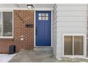 Blue front door with glass panels and brick surround at 12352 E 30Th Ave, Aurora, CO 80011