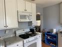 Bright kitchen features white cabinets, appliances, and granite countertops at 75 Pierce St, Lakewood, CO 80226