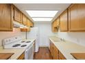 Compact kitchen with white appliances, wooden cabinets, and laminate countertops at 1301 S Cathay Ct # 104, Aurora, CO 80017