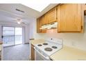 Efficient kitchen with wooden cabinets and sliding door to deck at 1301 S Cathay Ct # 104, Aurora, CO 80017