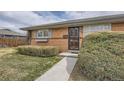 Welcoming brick home featuring a decorative security door and meticulously manicured shrubbery at 170 S Fenton St, Lakewood, CO 80226