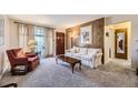 Comfortable living room with neutral carpeting, wood paneling, and a bright window at 170 S Fenton St, Lakewood, CO 80226