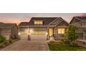 Charming two-story home at sunset featuring a three-car garage and stone accents at 5597 Pinto Valley St, Parker, CO 80134
