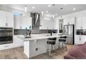 Bright and open kitchen with white cabinets, stainless steel appliances and large island at 5597 Pinto Valley St, Parker, CO 80134