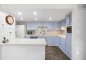 Well-lit kitchen features painted cabinets, white countertops, and stainless appliances at 7172 S Vine Cir, Centennial, CO 80122