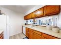 Functional kitchen with wooden cabinetry offering a view into the living room at 3600 S Pierce St # 5-202, Denver, CO 80235