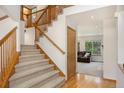 Spacious entryway with hardwood floors, a carpeted staircase, and a view into the living room at 9346 Lark Sparrow Dr, Highlands Ranch, CO 80126