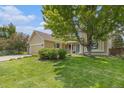 Inviting two-story home with well-maintained lawn, mature trees, and a charming, covered front porch at 9346 Lark Sparrow Dr, Highlands Ranch, CO 80126