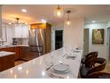 Well-lit kitchen with stainless steel appliances and a spacious marble counter with seating at 8950 W 26Th, Lakewood, CO 80215