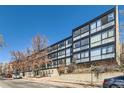 Modern building with multiple units and large windows offering natural light and views, situated on a tree-lined street at 1050 N Corona St # 308, Denver, CO 80218