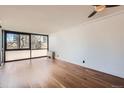 This is an empty living room featuring hardwood floors and a large window at 1050 N Corona St # 308, Denver, CO 80218