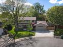 An elevated shot of a two-story home featuring a well-kept lawn, driveway, and mature trees at 4175 S Sidney Ct, Denver, CO 80237