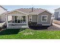 Inviting back patio with covered porch, ideal for outdoor dining and relaxation at 10553 Xenia Ct, Commerce City, CO 80640