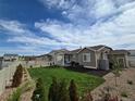 Spacious fenced backyard featuring lush lawn, mature landscaping, and a private outdoor space at 10553 Xenia Ct, Commerce City, CO 80640