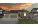 Charming one-story home featuring a three-car garage, bathed in a beautiful sunset at 10553 Xenia Ct, Commerce City, CO 80640