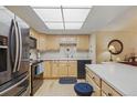 Bright kitchen features wood cabinets, white counters, stainless steel appliances, and a unique decorative clock at 13631 E Marina Dr # 502, Aurora, CO 80014