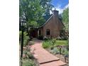 Charming brick home with a lush garden, stone walkway, chimney and arched entry at 357 Birch St, Denver, CO 80220