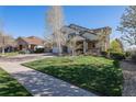 Beautifully landscaped front yard, mature trees, and a two-story home with stone and siding exterior at 26861 E Clifton Dr, Aurora, CO 80016