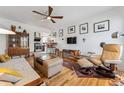 Bright living room featuring a ceiling fan, hardwood floors, and a comfortable seating area at 2024 Ford St, Golden, CO 80401