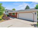 An attached garage is shown in this exterior view of this home with a brick facade at 370 S Parfet St, Lakewood, CO 80226