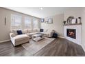 Inviting living room features a fireplace, large windows, and a plush sectional sofa with stylish decor at 14100 Shasta Daisy St, Parker, CO 80134
