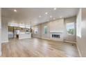 Open concept living area features modern fireplace, wood floors, and lots of natural light at 6799 Navajo St, Denver, CO 80221