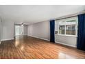 Bright living room featuring beautiful wood floors and large windows with stylish curtains at 2308 Lima St, Aurora, CO 80010