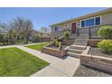 Close-up of the front yard with tiered landscaping and concrete pathway at 6488 E 63Rd Pl, Commerce City, CO 80022
