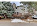Back exterior view showcasing a private deck, mature trees, and tidy landscaping at 4605 S Yosemite St # 39, Denver, CO 80237
