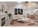 Bright living room featuring high ceilings, modern decor, fireplace, and staircase at 4605 S Yosemite St # 39, Denver, CO 80237