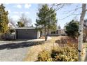 Home with detached garage with a gravel driveway and mature landscaping and greenery at 2360 Estes St, Lakewood, CO 80215